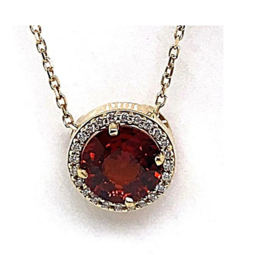 Indulge in the elegance of this 14K yellow gold necklace, showcasing a stunning 1.70 ct round brilliant mandarin garnet centerpiece encircled by .06 ct tw natural round brilliant diamond accents in a halo style.