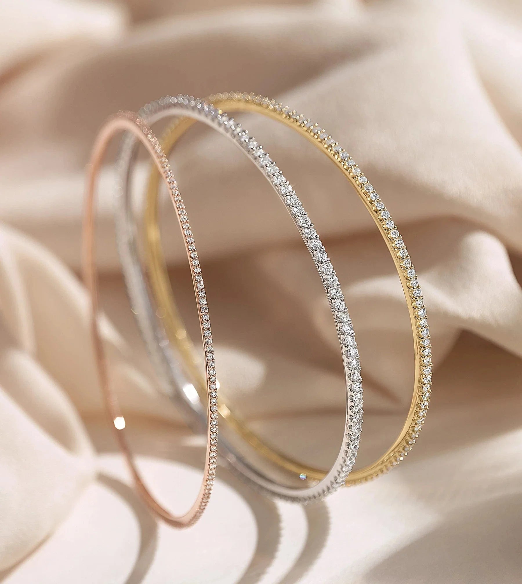 3 diamond flex bracelets on a peach silk background
