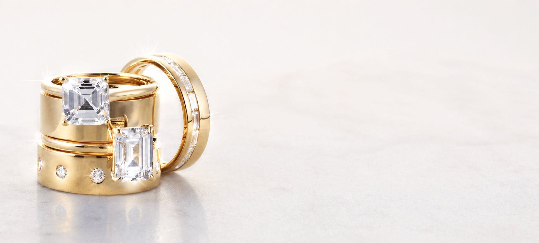 Gold rings with gemstones on a light gray background