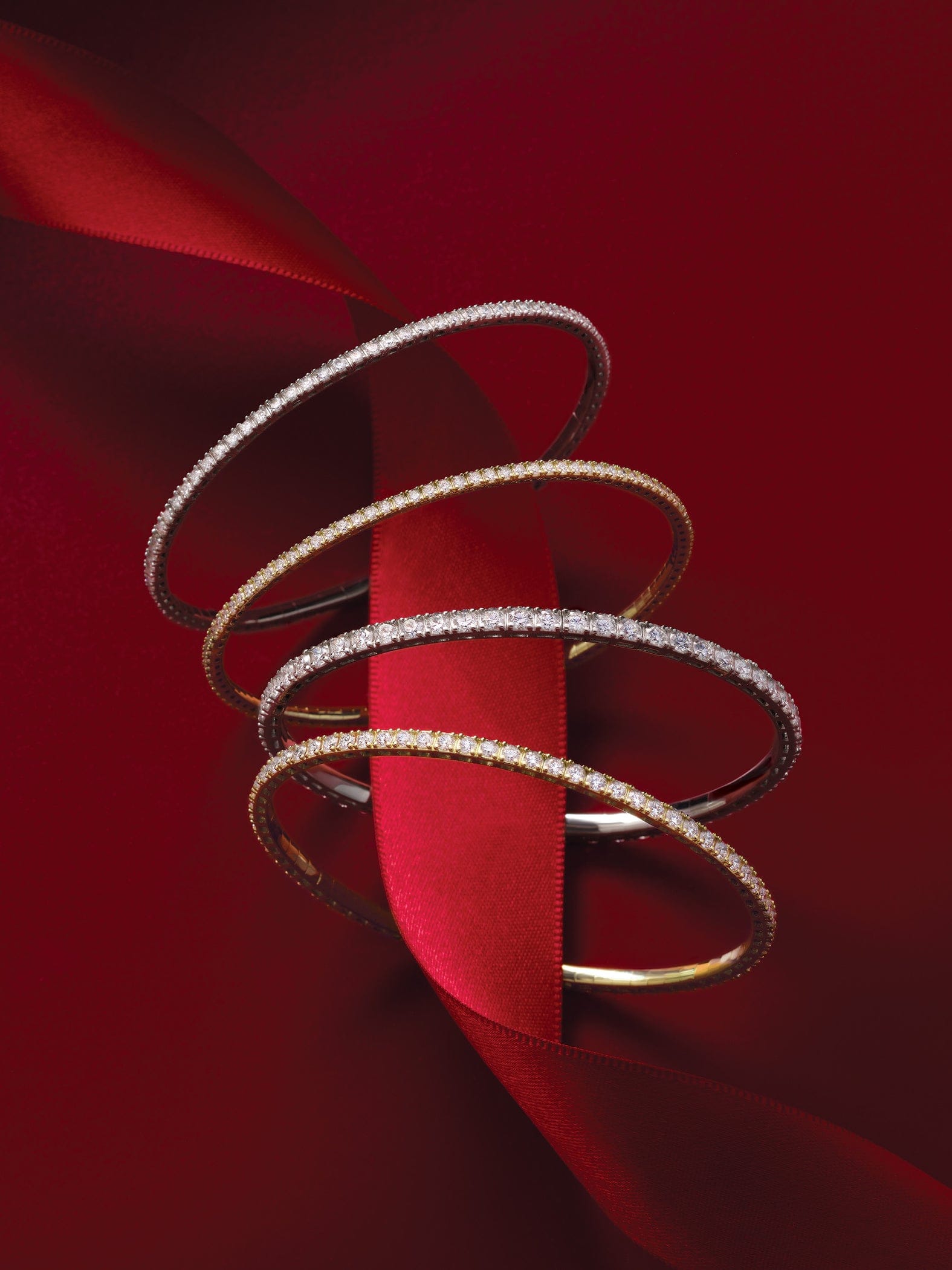 Gold bangle bracelets on a red fabric background