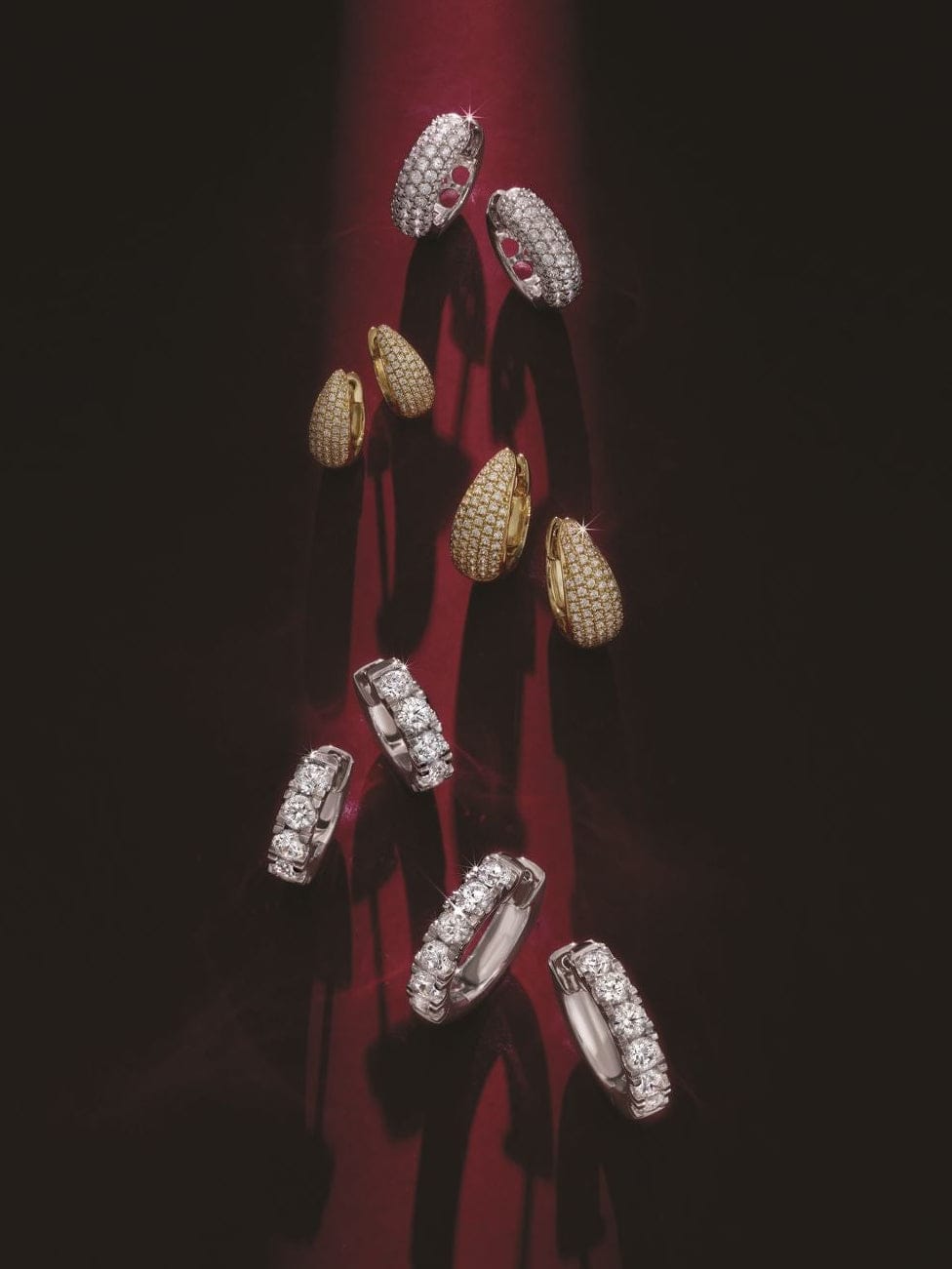 Diamond hoop earrings on a red and black background