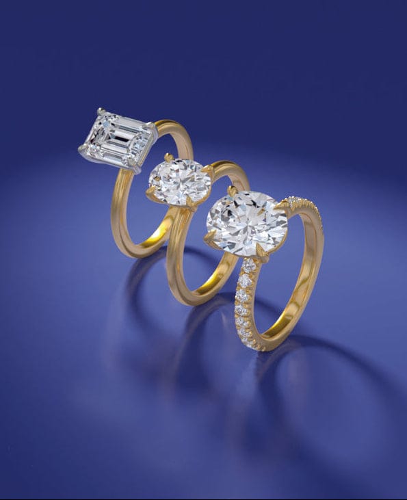 Gold engagement ring with lab grown diamonds on a blue background