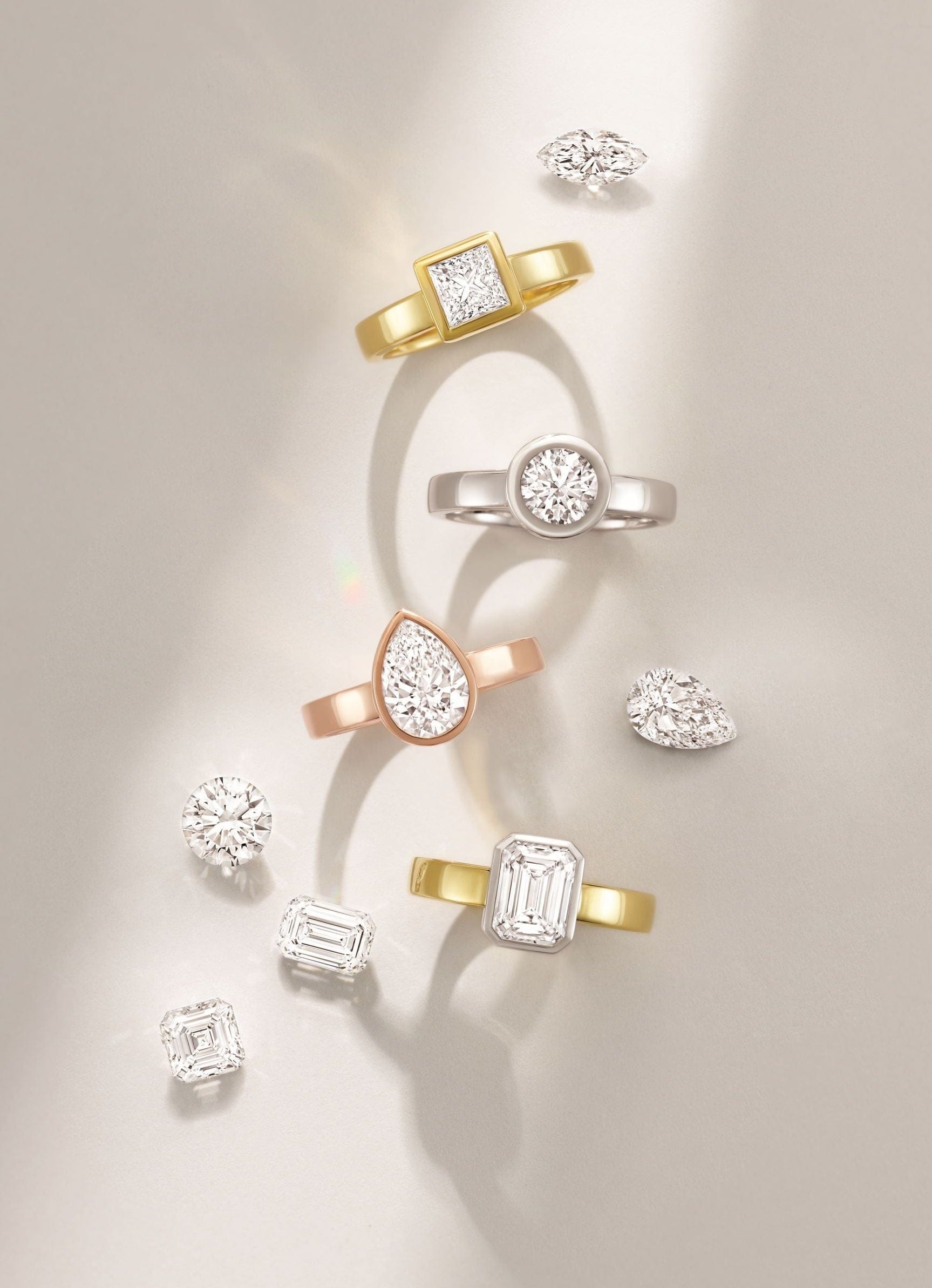 Collection of lab grown diamond engagement rings on a light background