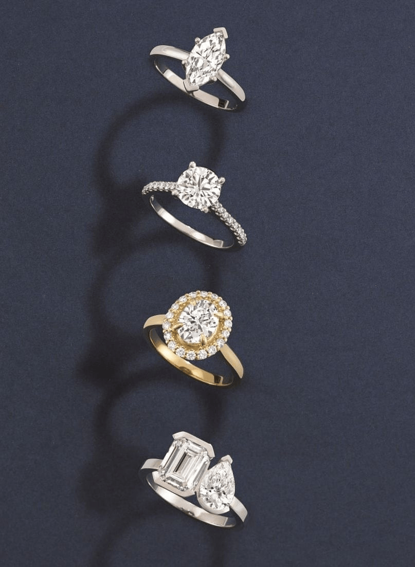 Four diamond custom engagement rings in different designs on a dark blue background