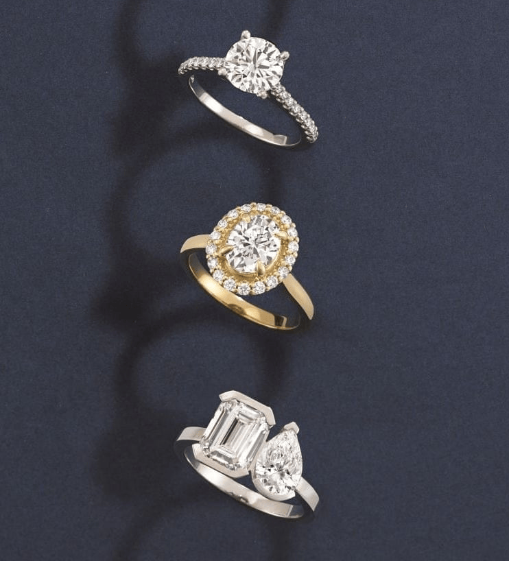 Three diamond engagement rings with different designs on a dark background