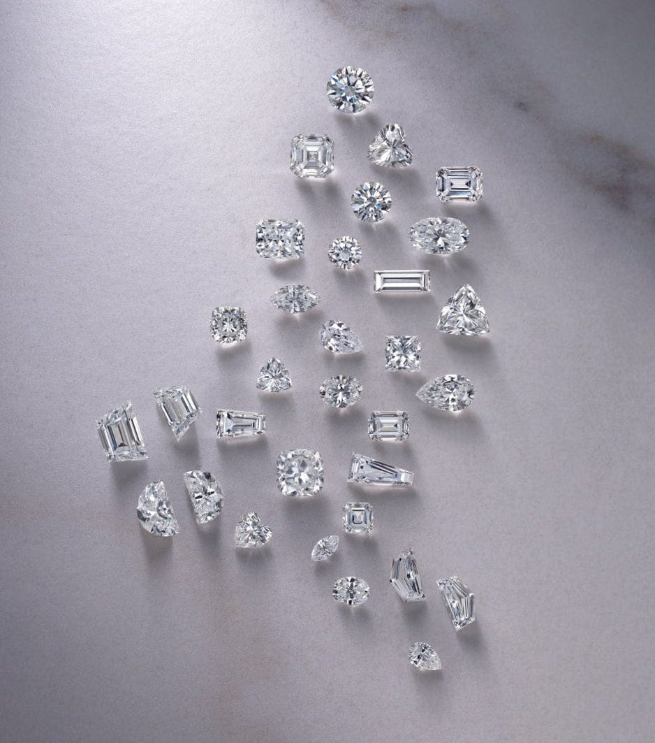 Collection of LOOSE LAB GROWN diamonds arranged in a fan-like pattern on a marble surface