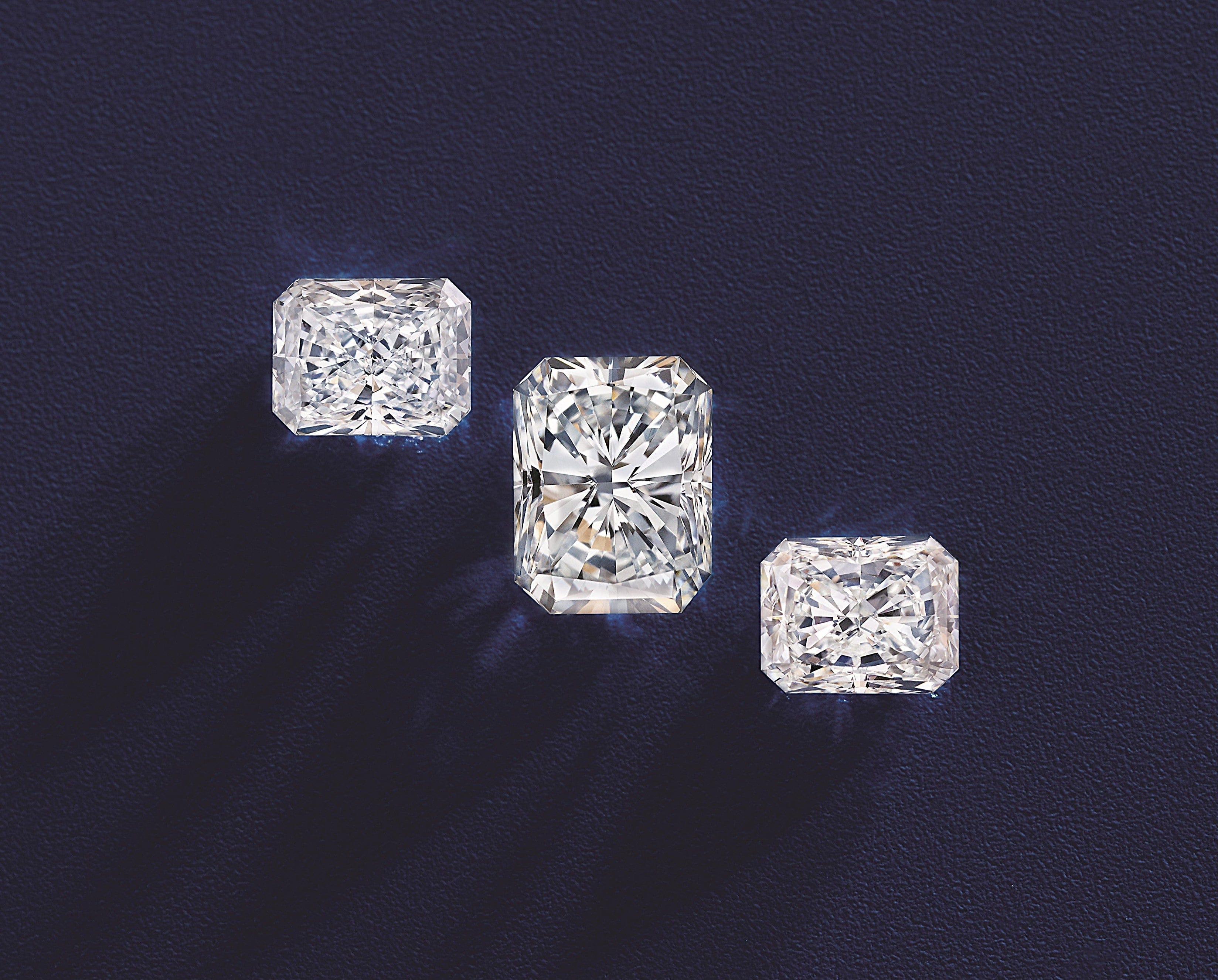 3 radiant cut diamonds on a dark blue background