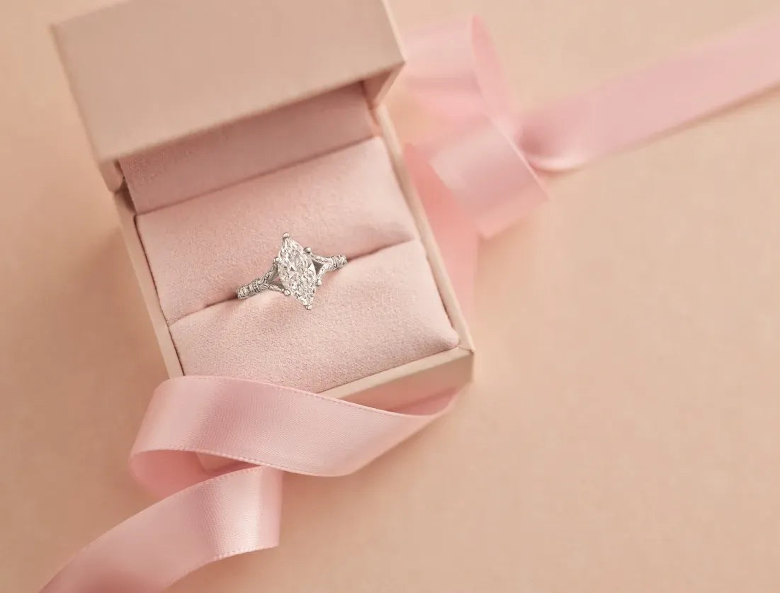 Diamond engagement ring in a pink box with a pink ribbon