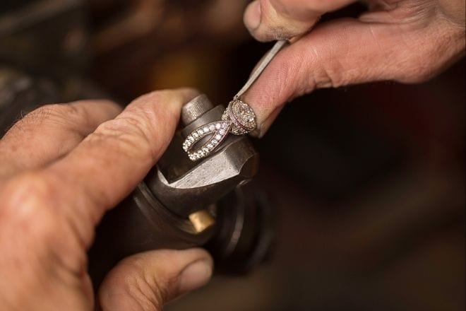 A jeweler setting diamonds into a ring using a precision tool.