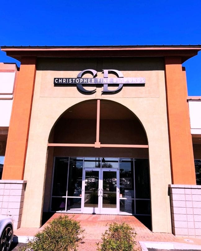 Building entrance with 'Christopher Fine Jewelers' sign against a blue sky