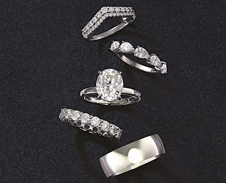 Five wedding bands arranged on a dark surface, featuring diamond accents with various cuts and a polished plain metal band.